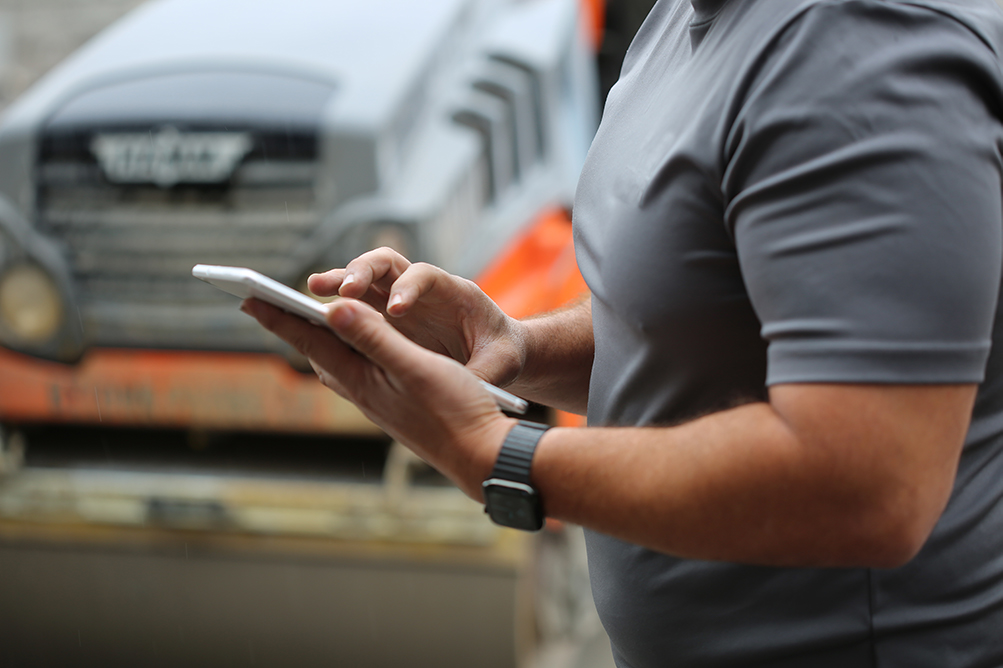 worker using iPad to review telematics data for his fleet of trucks